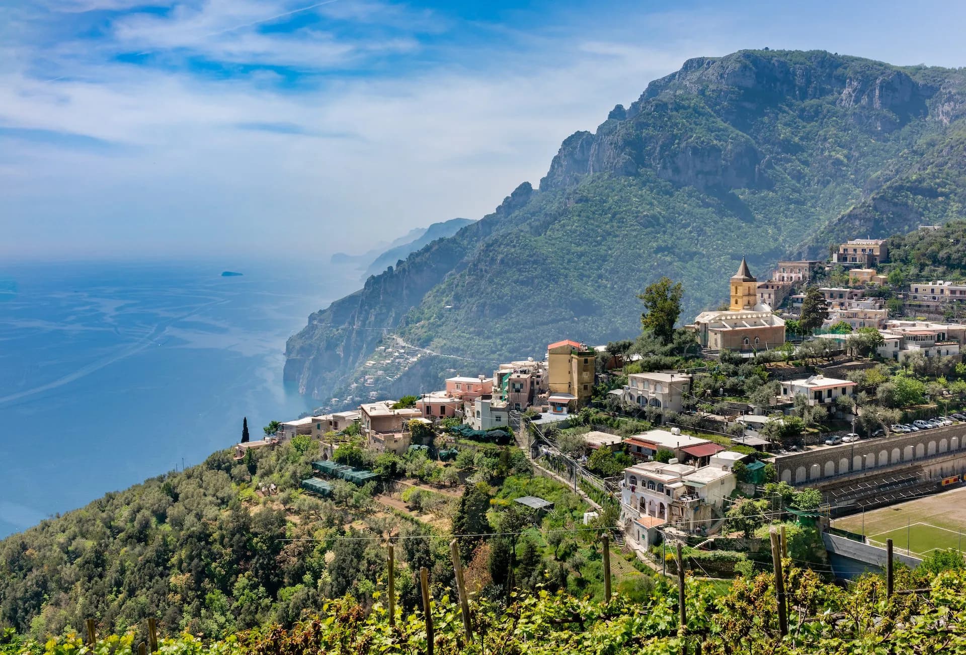 Vineyard overlooking Montepertuso village on steep hillside above the blue sea.