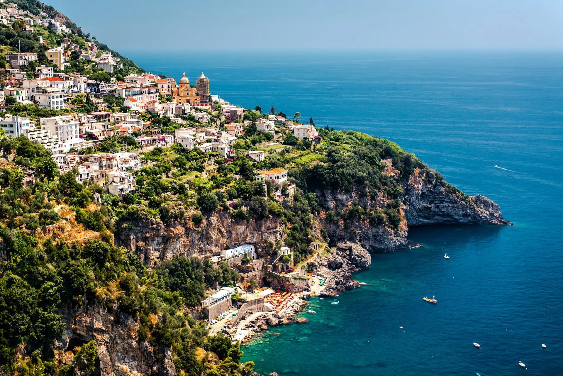 View of Praiano town built into steep cliffs above the deep blue Mediterranean Sea.