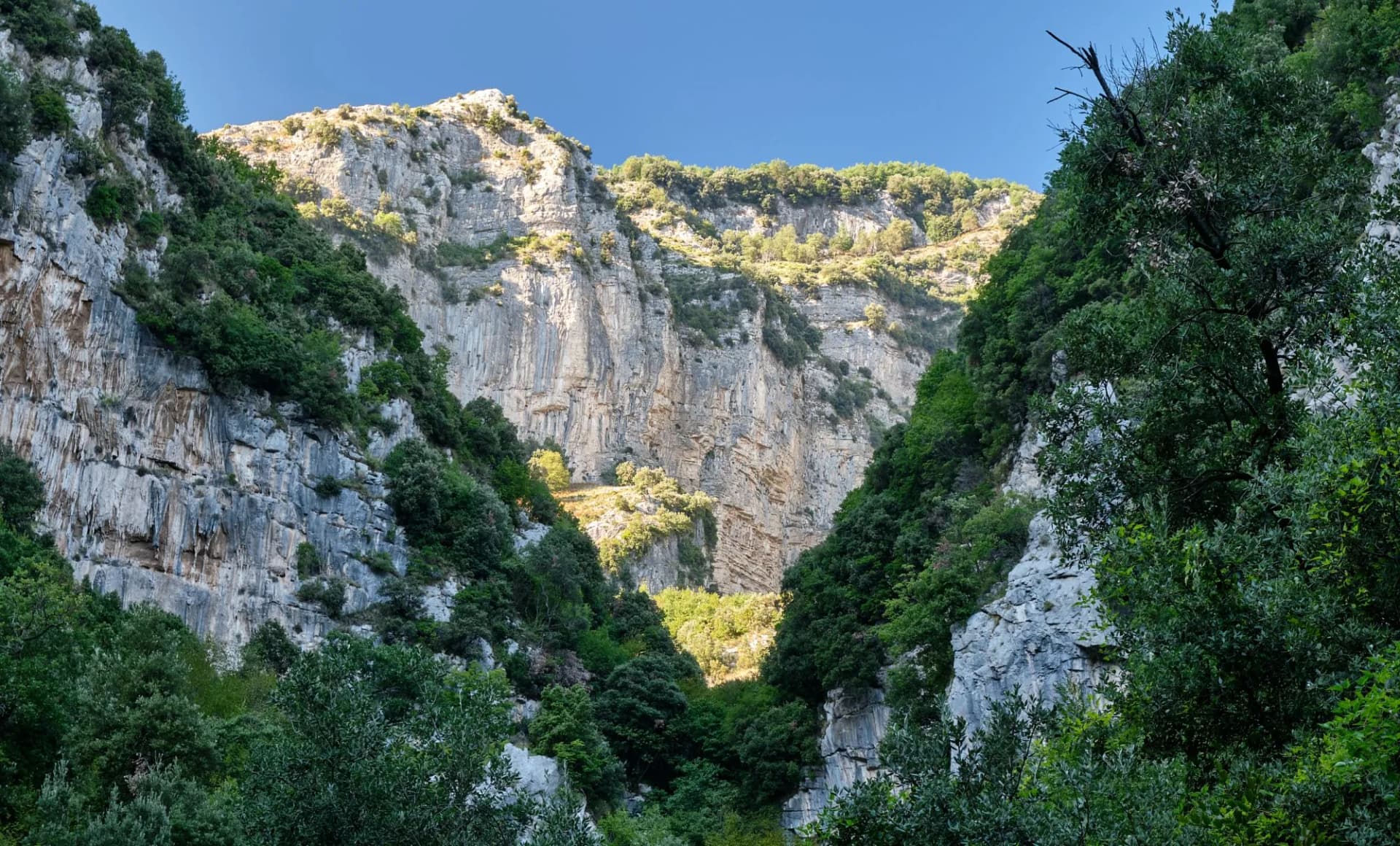 A V-shaped cleft in the mountains of Valle delle Ferriere is highlighted by sunlight